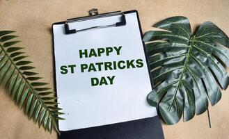 Concept of Happy St. Patrick's Day write on paperwork isolated on Wooden Table. photo