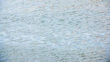 Water surface, river ripples or ocean with small waves, calm and close-up. Natural background. Abstract background, texture. photo