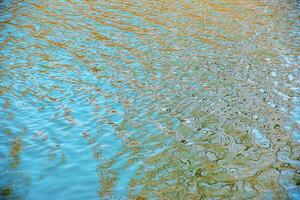Water surface in sunset rays, river ripples or ocean with small waves, calm and close-up. Abstract background, texture. photo