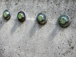 Close up of four bolts and washers fastening on a concrete surface. photo