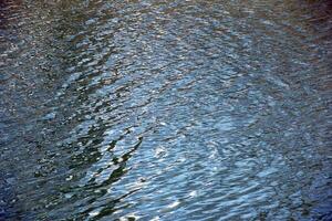 Water surface in cloudy weather, ripples of river or ocean with small waves, calm and close-up. Natural background. Abstract background, texture. photo
