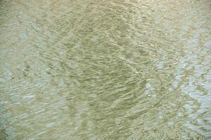 Water surface in sunset rays, river ripples or ocean with small waves, close-up. Natural background. Abstract background, texture. photo