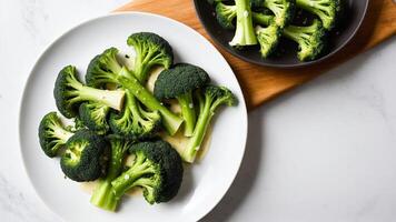 Broccoli on a white plate with a bowl of sauce photo