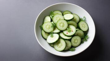 A bowl of cucumbers on a table photo