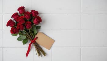 Elegant Red Rose Bouquet with Blank Tag on White Wooden Surface photo