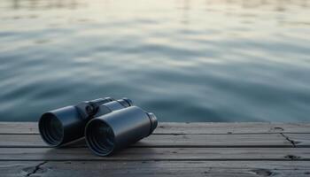 Binoculars on Dock Next to Calm Water at Sunset Time photo