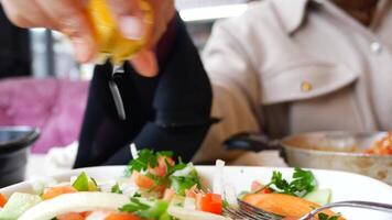 Fresh salad preparation with citrus dressing in a cozy restaurant video