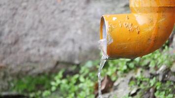 Water flowing from an orange pipe in a natural setting video