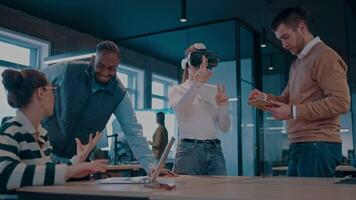 Disabled businesswoman in a wheelchair working in modern coworking office. Team around is using virtual reality goggles, collaborating with the latest technology in an open space startup creative video