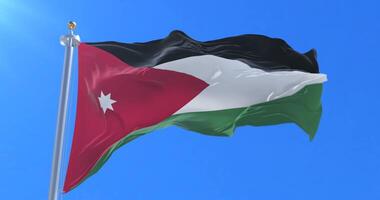 Flag of Jordan waving at wind with blue sky in slow, loop video