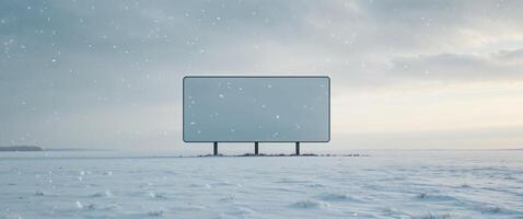 A large white billboard sits in a field of snow. photo