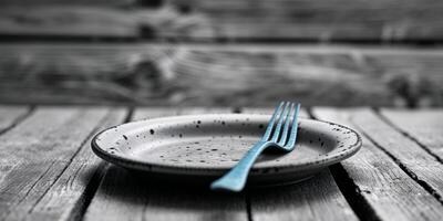 A fork and plate on a wooden table photo
