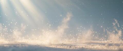 Snow falling on the ground with sun rays shining through photo
