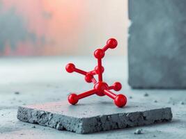 A red model of a molecule on a concrete block photo