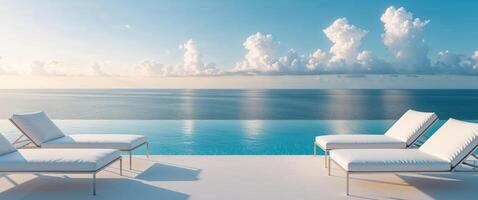 White lounge chairs by the pool with the ocean in the background photo