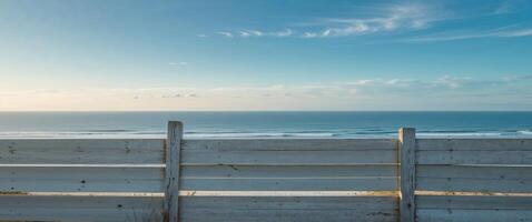A white fence with a view of the ocean photo