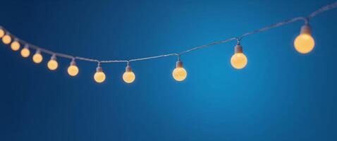 A bunch of lights hanging from a string on a blue background. photo