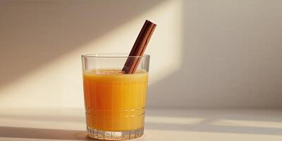 Refreshing Glass of Orange Juice Garnished with Cinnamon Stick for Flavor. photo