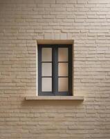 A brick wall with a small window in the middle photo