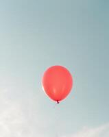 A red balloon is floating in the sky photo