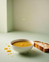 A bowl of soup and a slice of bread on a table photo