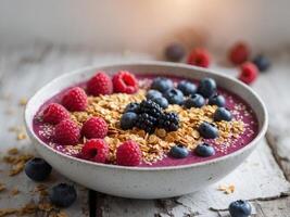 A bowl of berry smoothie with granola and berries on a wooden table photo