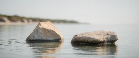 There are two rocks in the water near the shore photo