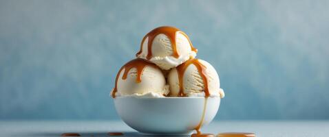 Delicious vanilla ice cream scoops with caramel topping in a bowl. photo