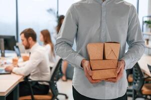 Man with ecoboxes that is with food is in the office photo