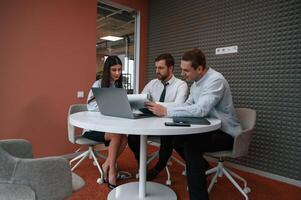 Office workers are indoors by the table.. photo