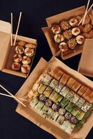 Top view of sushi rolls that is in the paper eco boxes on the table photo