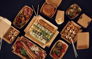 Top ,view of table with food on it. Meat,, vegetables, sushi, French fries, burger, mushrooms photo