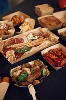 Top view of table with food on it.. Meat, vegetables, French fries, burger, mushrooms photo