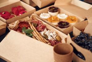 Close up view of table with food, on it. Meat,, vegetables, sushi, French fries, burger, mushrooms photo