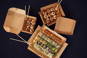 Top view of sushi rolls that is in the paper ,eco boxes on the table photo