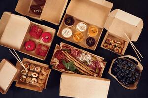 View ,from the top of table with food on it. .Meat, vegetables, sushi, French fries, burger, mushrooms photo