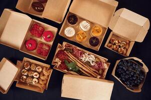 View from the, top, of, table with food on it. Meat, vegetables, sushi, French fries, burger, mushrooms photo
