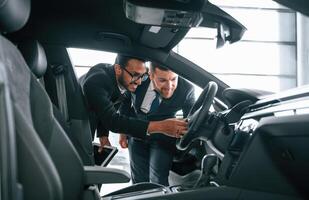 Man showing, automobile interior to the customer photo