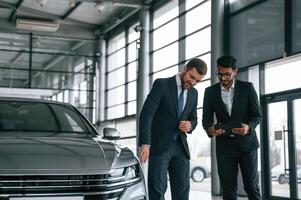 Man is,, consulting the customer in the car showroom photo