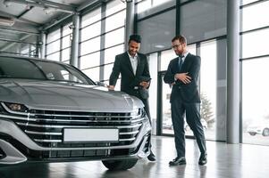 Talking about ,automobile. Man is consulting the customer in the car showroom photo