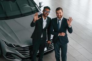 View from the top. Two businessmen are working ,together in the car showroom photo