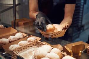 Delicious donuts. Man is, taking food in the workspace. Conception of sweet desserts photo