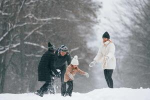 Playin, snowballs. Happy family is outdoors, enjoying snow time at winter together photo