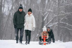 Sled ride. Happy ,family is outdoors, enjoying snow time at winter together photo