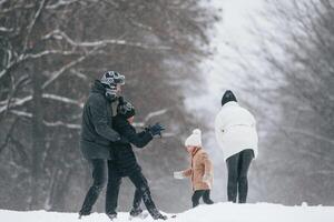 Playing, snowballs. Happy family ,is outdoors, enjoying snow time at winter together photo