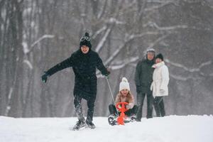 Having fun by ,riding sled.. Happy family is outdoors, enjoying snow time at winter together photo