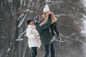 Having, fun, holding ,girl on the hands. Mother and father is with daughter have walk outdoors at the winter season photo