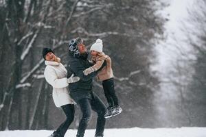 Having fun, holding,,girl on the hands. Mother and father is with daughter have walk outdoors at the winter season photo