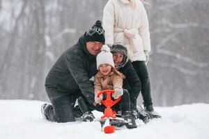 Sled,, ride. Happy family is outdoors, enjoying snow time at winter together photo