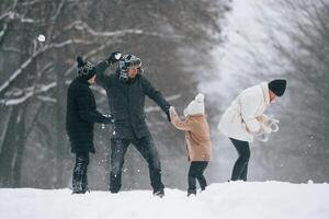 Playing ,snowballs.. Happy family is outdoors, enjoying snow time at winter together photo
